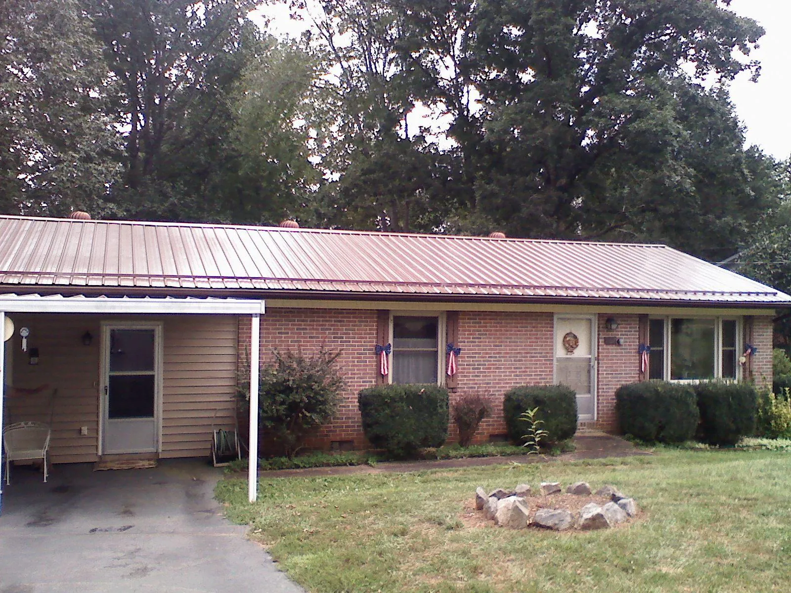 Bronze metal roof and carport on a brick ranch home — Roof Repair work by our crew in Zionville