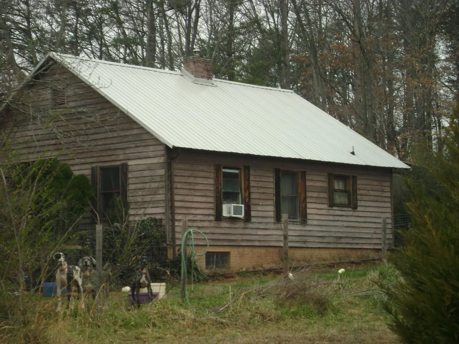 White metal roof on an old wood sided farmhouse, from a Metal Roof Installation job in Zionville